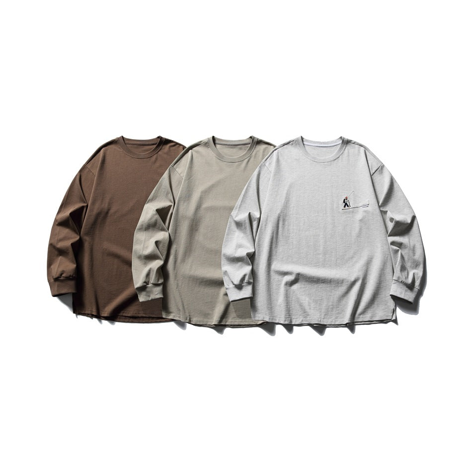 Three long-sleeve crewneck shirts shown from the front in brown, taupe, and light gray; the gray shirt has a chest pocket