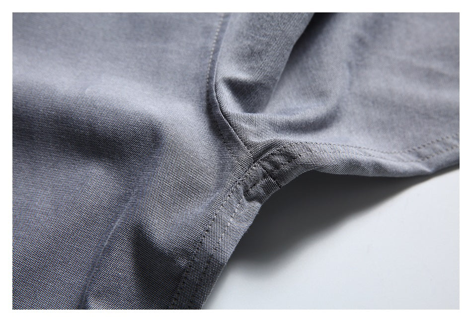 Close-up of gray shirt fabric and reinforced curved seam stitching.