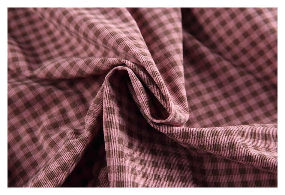 Close-up of pink and brown checked fabric draped into soft folds.