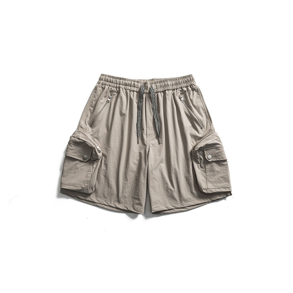 Light gray-taupe cargo shorts flat lay with drawstring waist, zip front pockets and snap-flap side cargo pockets
