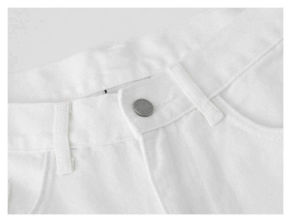Close-up of the white pants' front waistband, metal button, belt loop, and pocket edge.