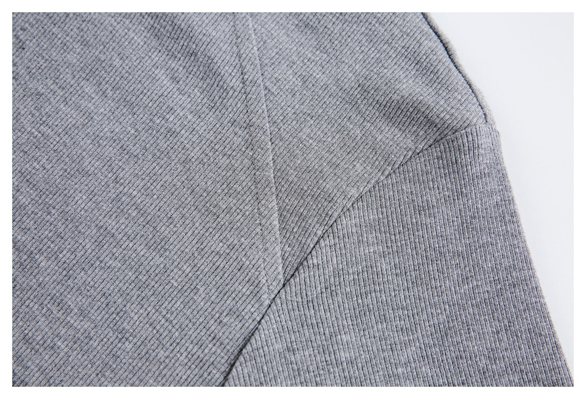 Close-up of gray ribbed shirt fabric and stitching at the shoulder and sleeve seam.
