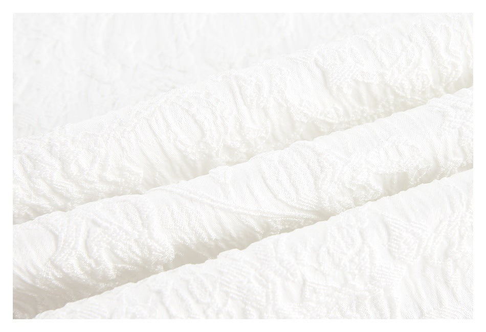Close-up of white fabric with a raised, wavy textured pattern.