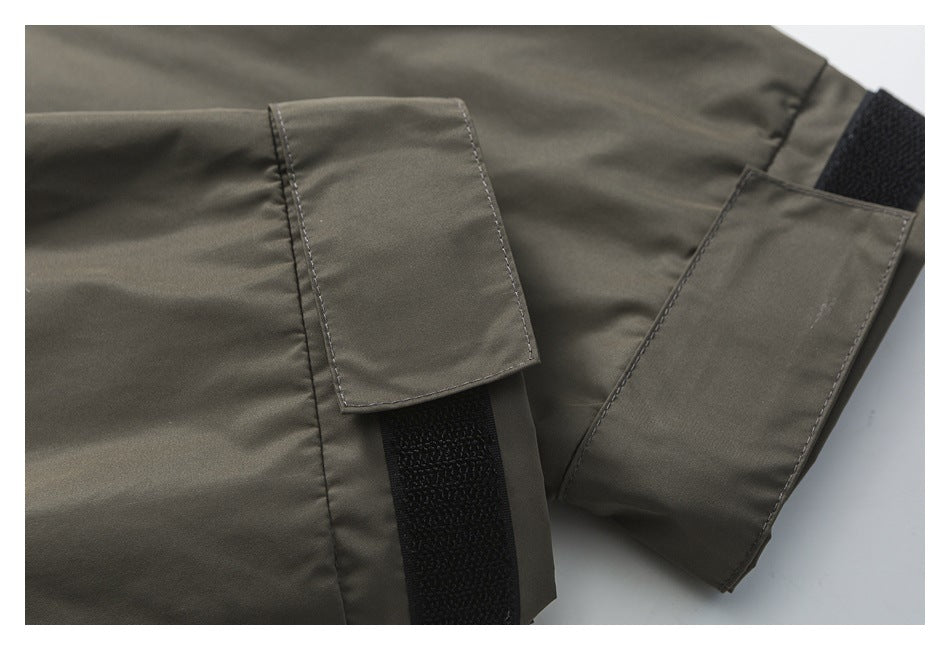 Close-up of gray-olive garment tabs with wide black hook-and-loop fasteners.