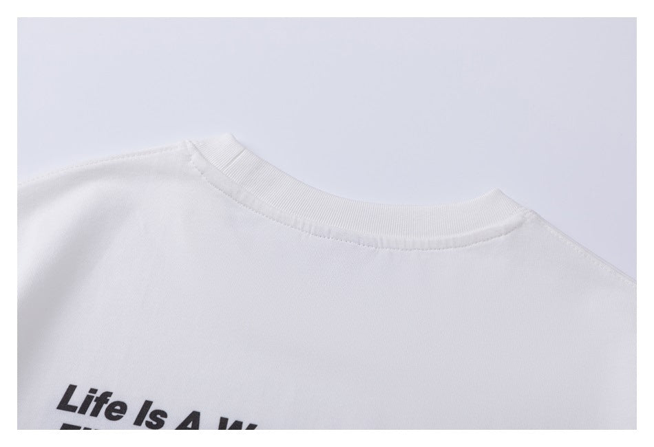 Close-up of the white T-shirt's ribbed neckline and upper back, with part of a black text graphic.