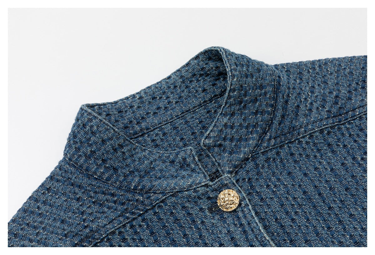 Close-up of the blue textured jacket's collar, stitching, and ornate gold button.