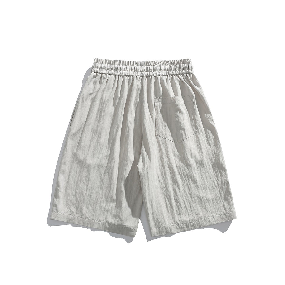 Light gray crinkled-texture shorts with elastic waistband and back patch pocket, flat lay back view