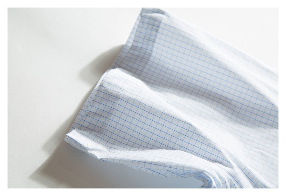 Folded section of a white shirt with a light blue grid pattern, showing the sleeve and stitched edge.