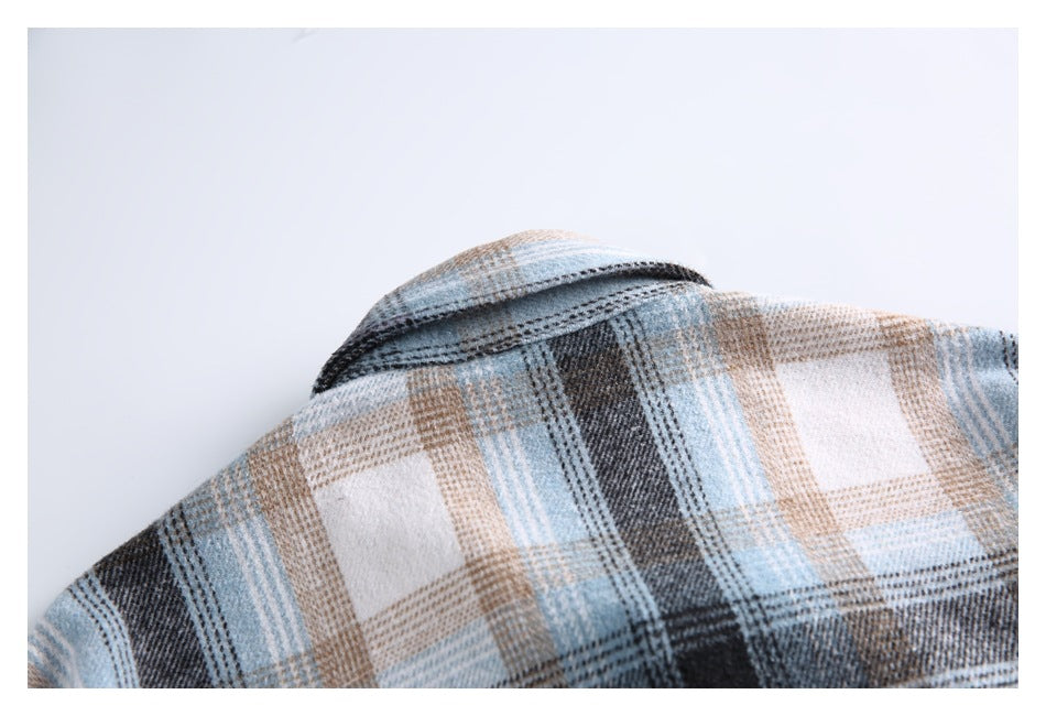 Close-up of the collar and shoulder of a blue, tan, and dark plaid shirt.