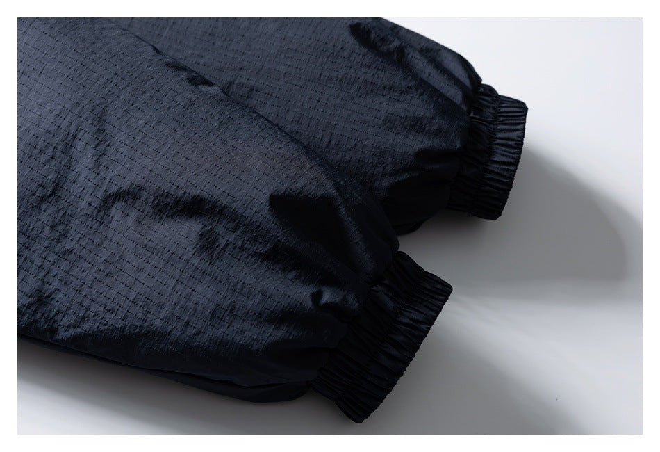 Close-up of the dark navy jacket's gathered elastic sleeve cuffs and textured fabric.
