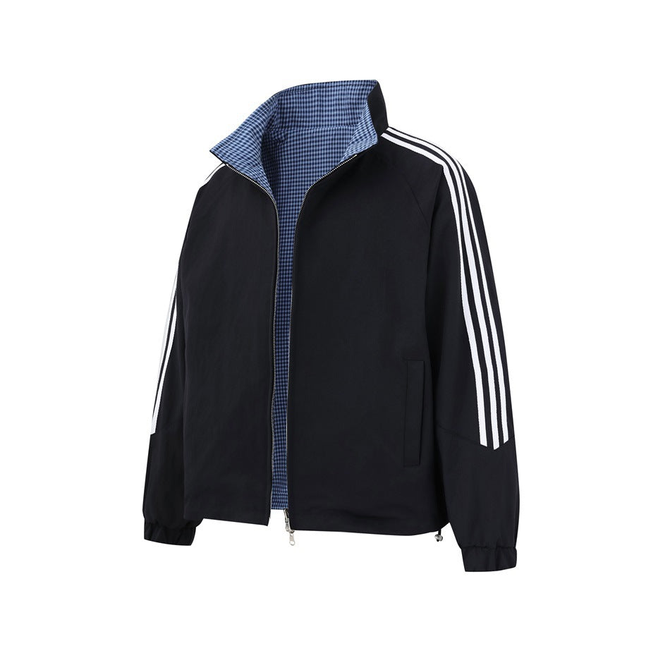 Front view of a black zip jacket with white sleeve stripes, pockets, and a blue check lining at the open collar and front.