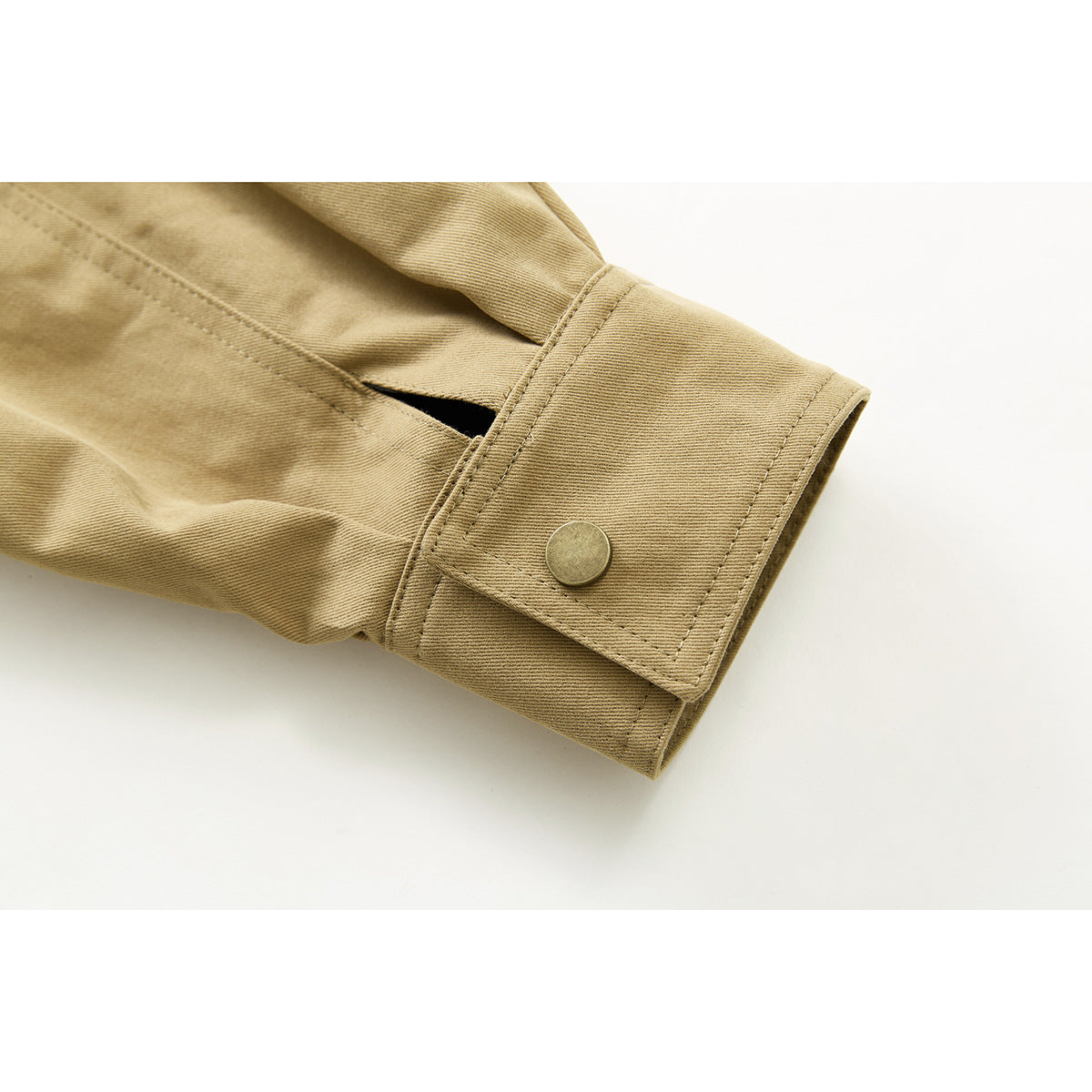 Close-up of a tan jacket sleeve cuff with a snap button and nearby sleeve vent.