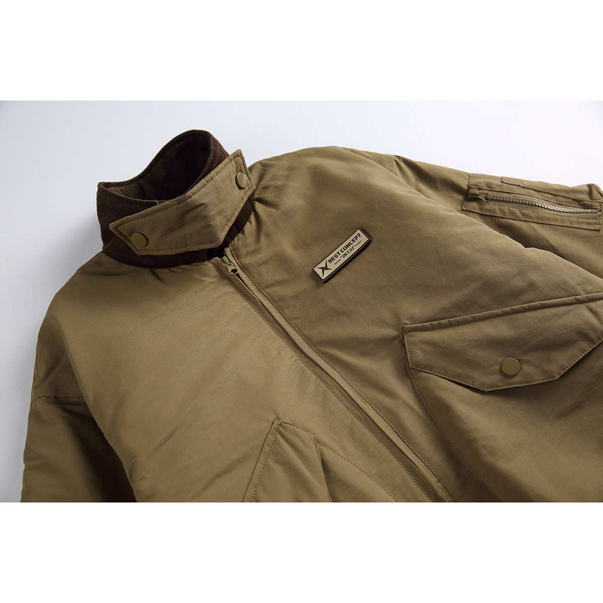 Close-up of a khaki bomber jacket collar, zip closure, chest patch pocket, and small branded chest label.