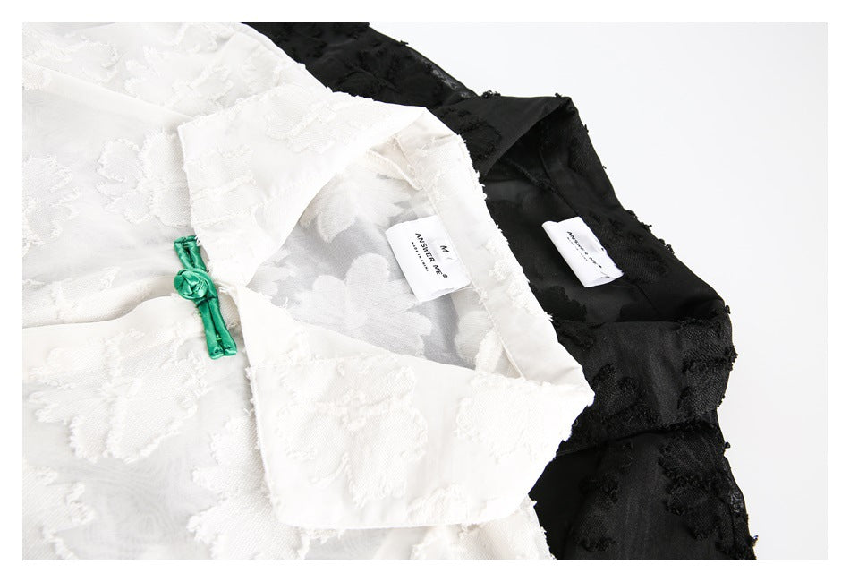 Close-up of the white and black floral shirts showing their collars, inside labels, and a green frog closure.