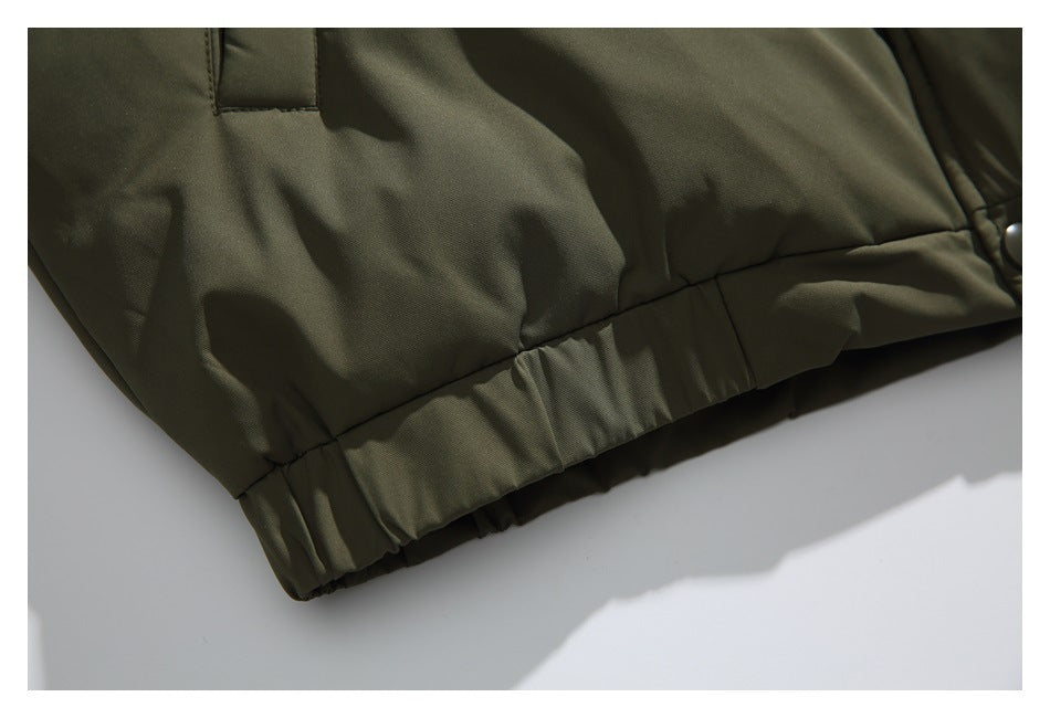 Close-up of the olive jacket's lower hem, with gathered elastic and quilted panels.