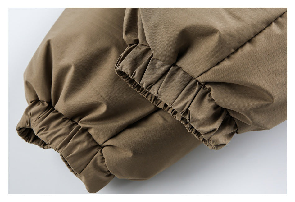 Close-up of tan garment sections with gathered elastic edges and stitched panels.