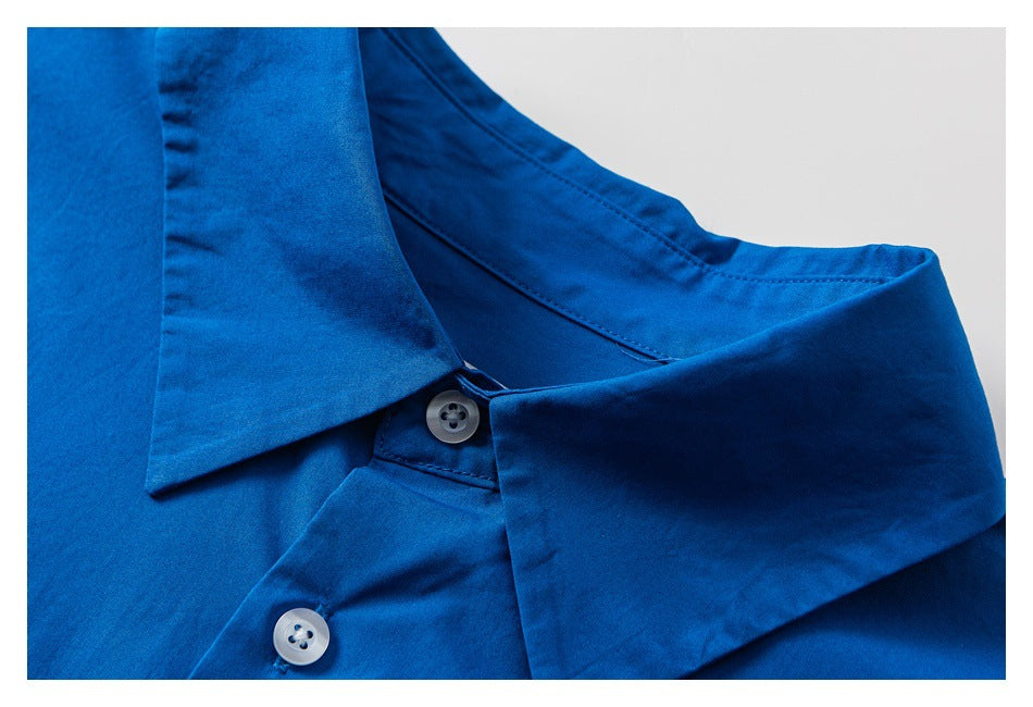 Close-up of a bright blue shirt collar and placket with two pale buttons.