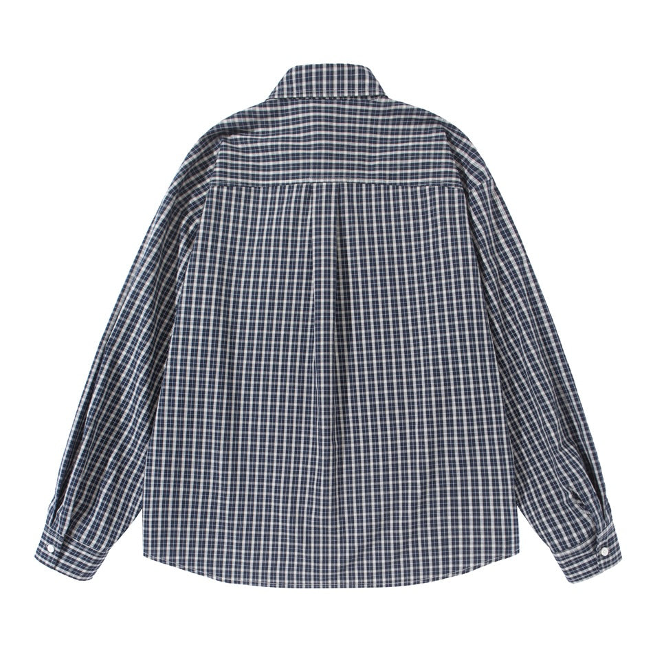 Flat back view of a navy and white plaid shirt showing back yoke, center pleat and buttoned cuffs