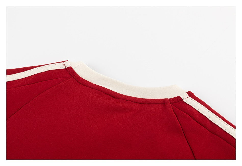 Close-up of the red shirt's cream crew neckline and cream shoulder stripes.