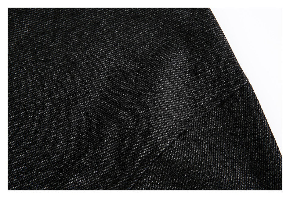 Close-up of black subtly textured fabric with a diagonal seam or overlapping edge.