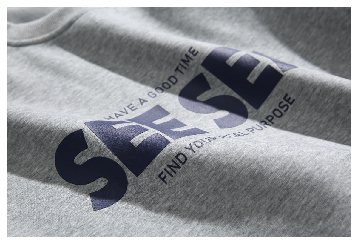 Close-up of dark lettering and a graphic printed on a heather gray sweatshirt.