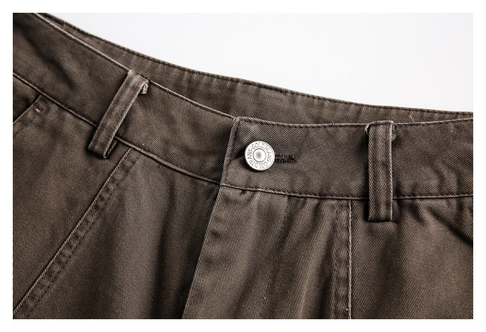 Close-up of the pants' waistband, belt loops, and round metal button.