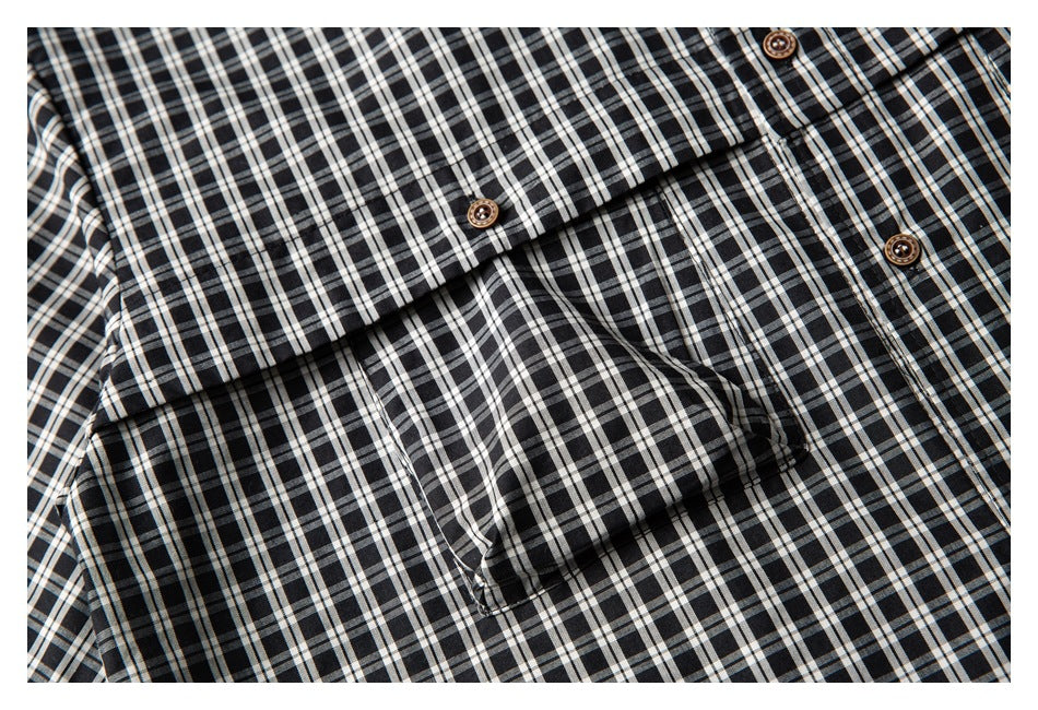 Close-up of the black-and-white checked shirt's chest pocket, placket, and brown buttons.