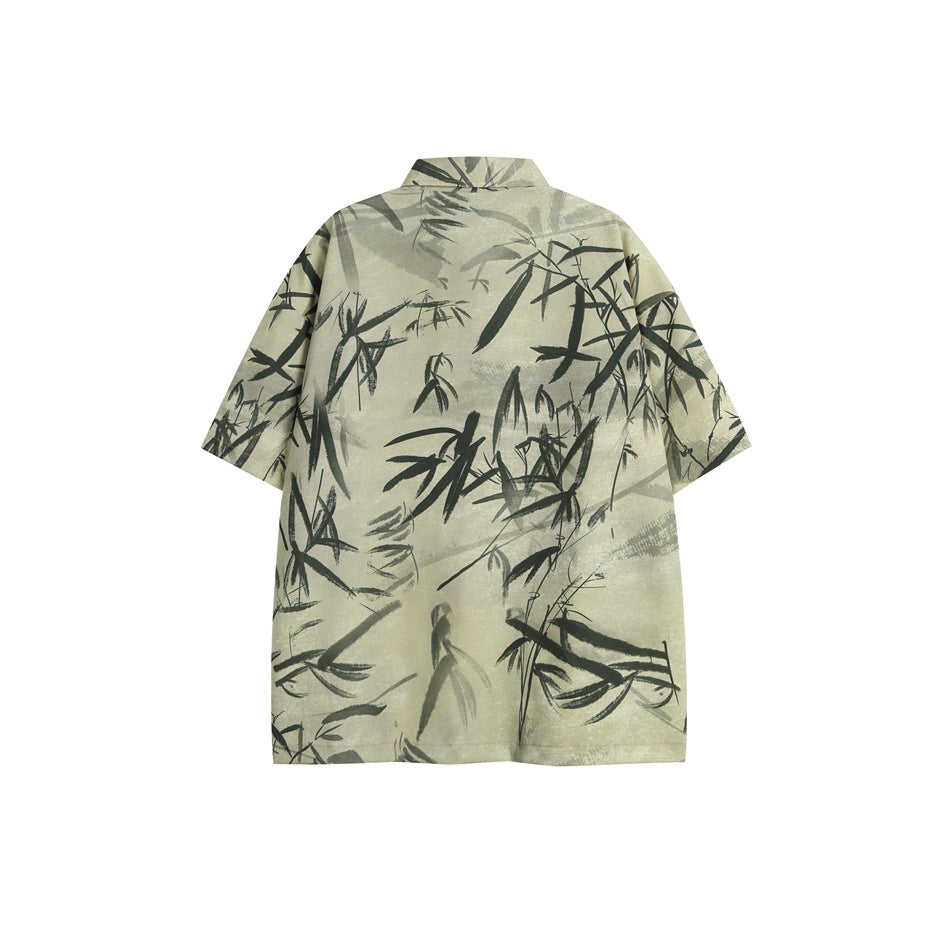 Flat-lay back of a beige short-sleeve shirt with a dark brush-painted bamboo-leaf print and a collar
