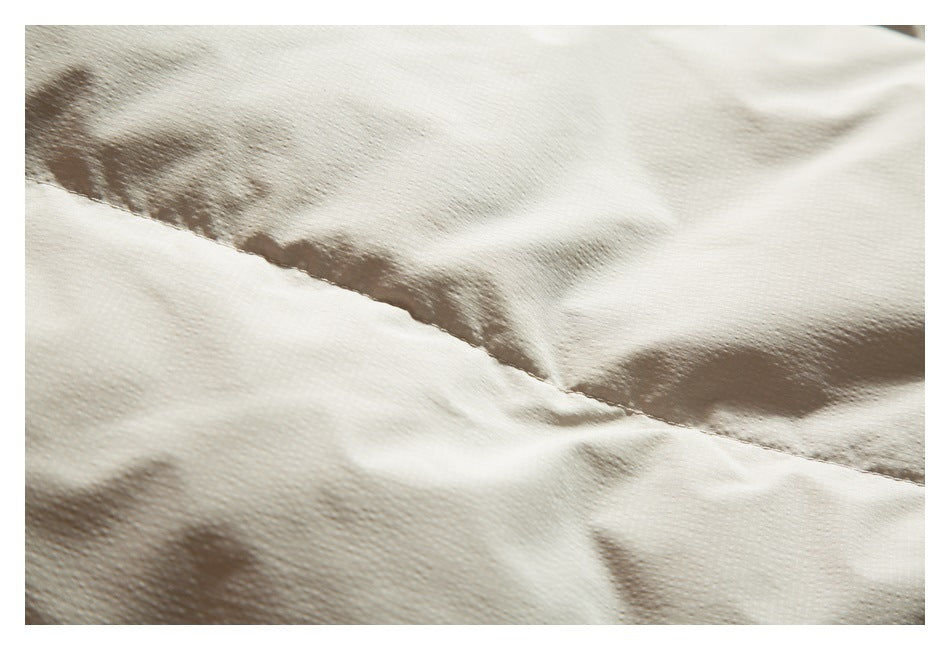 Close-up showing a stitched seam across cream-colored garment fabric.