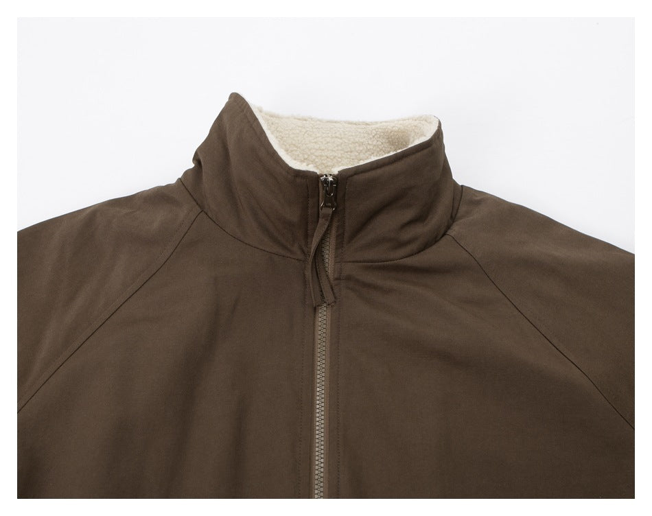 Close-up of the brown jacket's high collar, central zipper, and cream-colored textured lining.