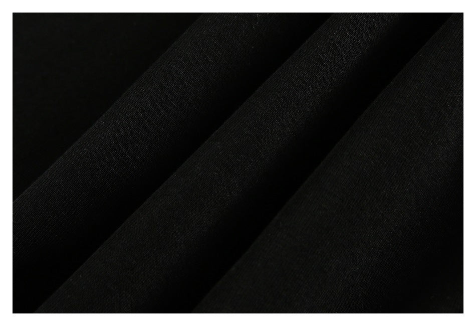 Close-up of black fabric arranged in diagonal folds, showing its fine textured surface.
