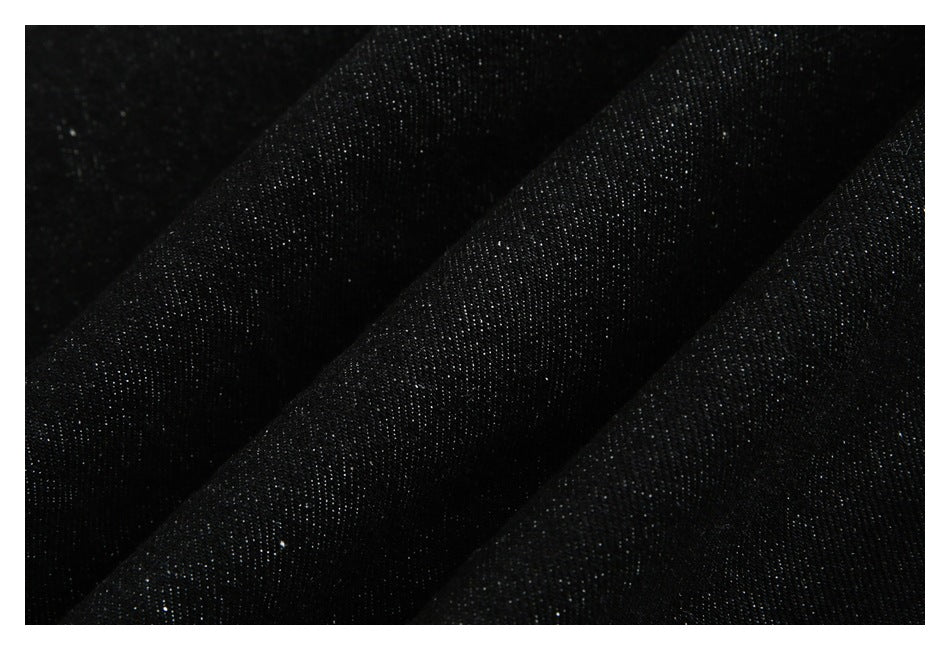 Extreme close-up of the dark, finely textured denim fabric.