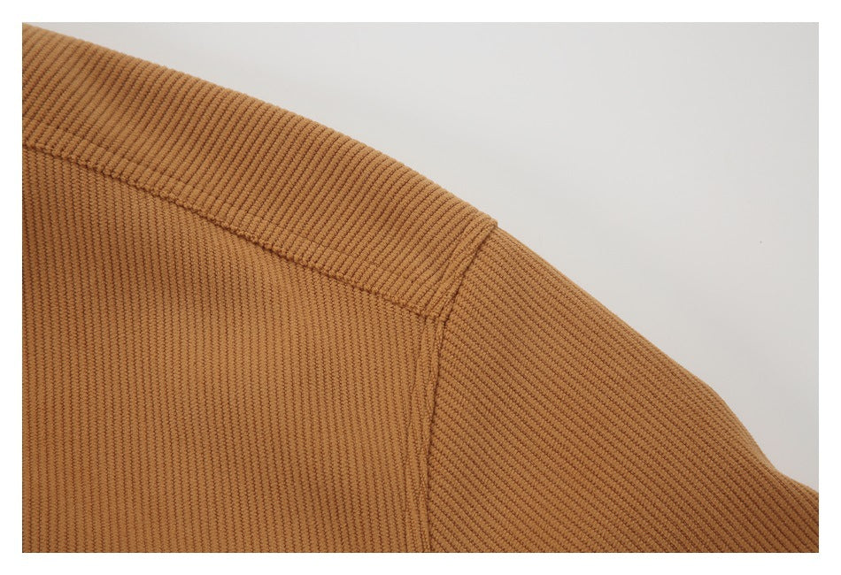 Close-up of a tan ribbed garment showing a shoulder seam and sleeve.