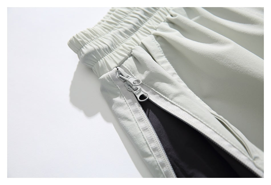 Close-up of light-colored shorts showing a side zipper pocket with the dark lining visible.