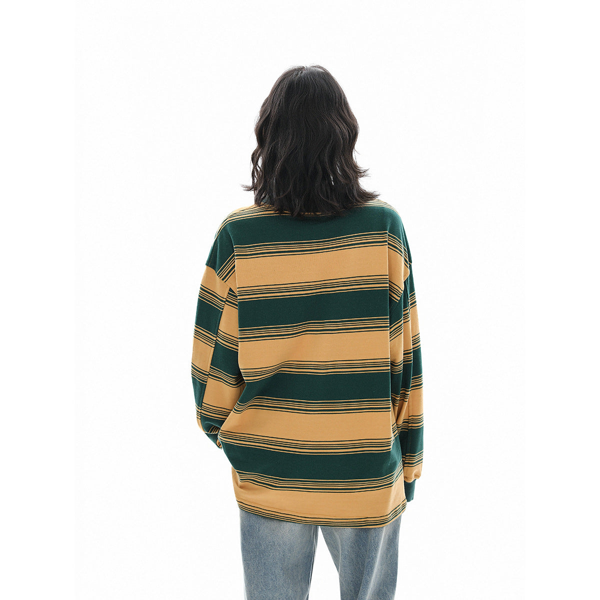 Back view of an oversized long-sleeve shirt with broad green and mustard horizontal stripes, worn with jeans.
