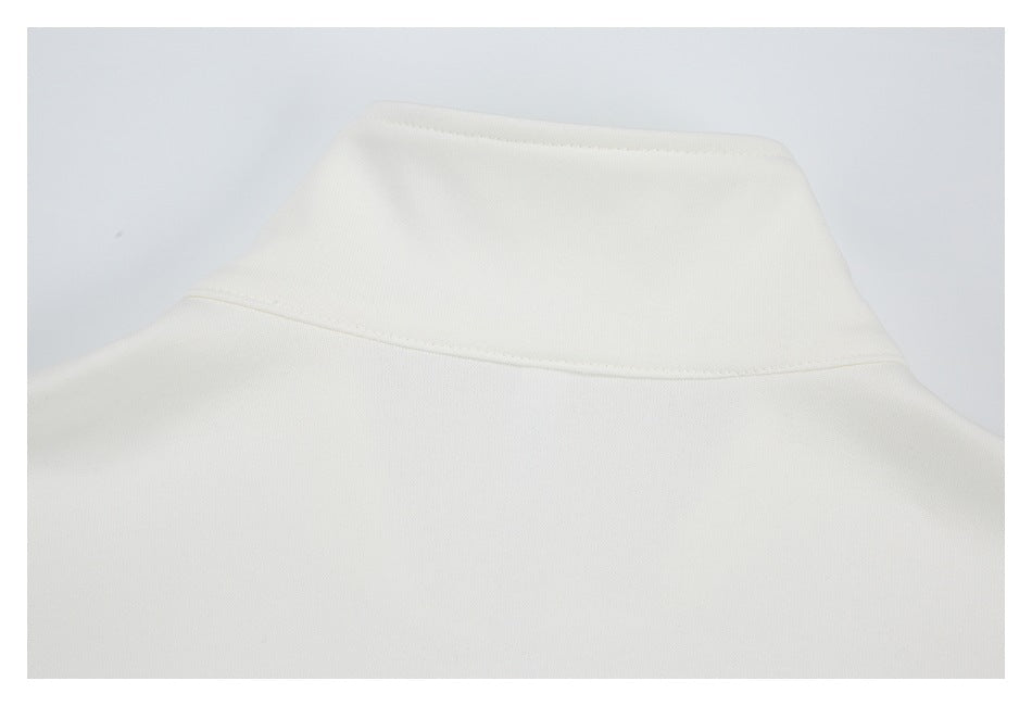 Close-up of the raised collar and upper back seam of a white garment.