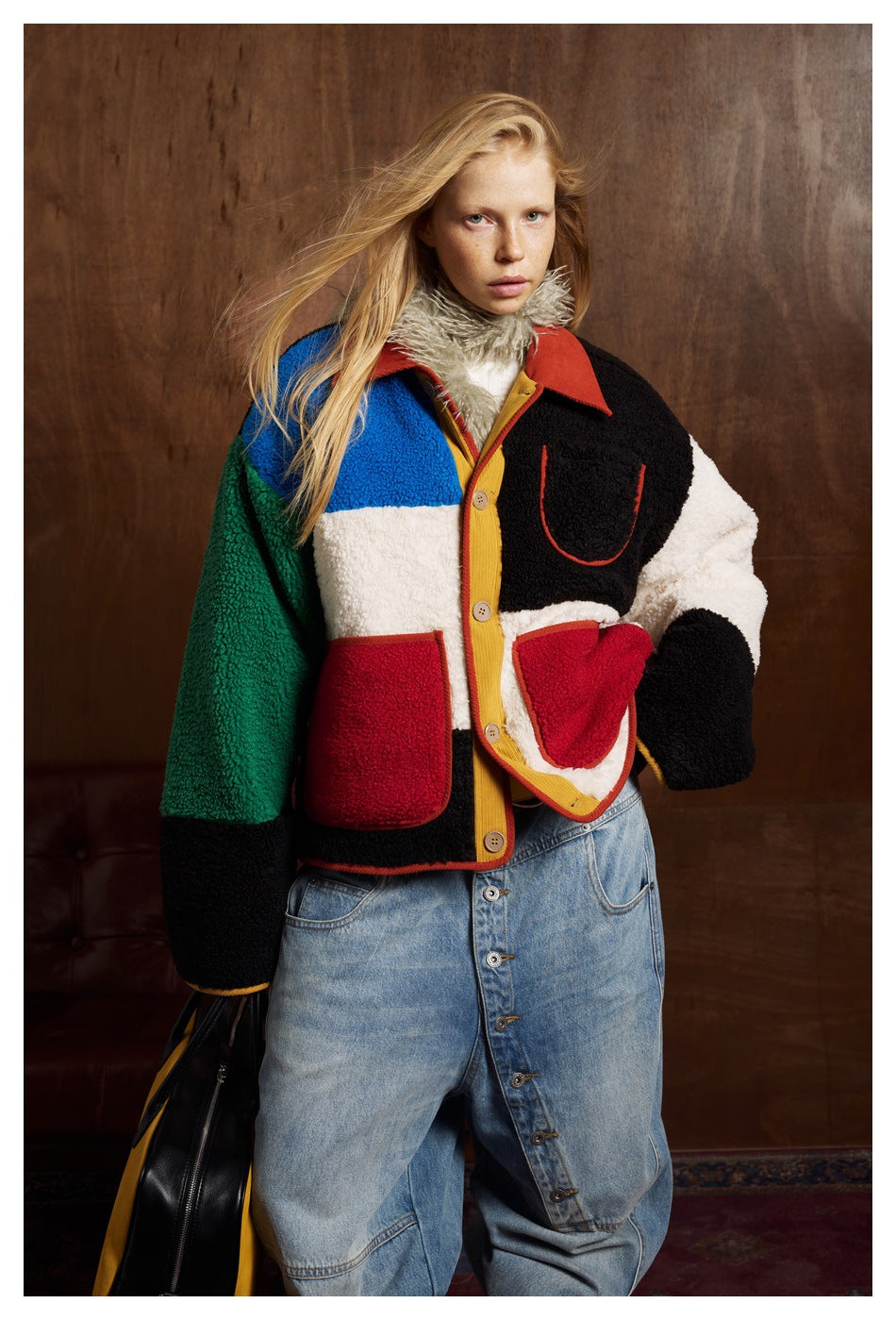 Model wearing a color-block fleece jacket with red trim, button closure and contrasting patch pockets.