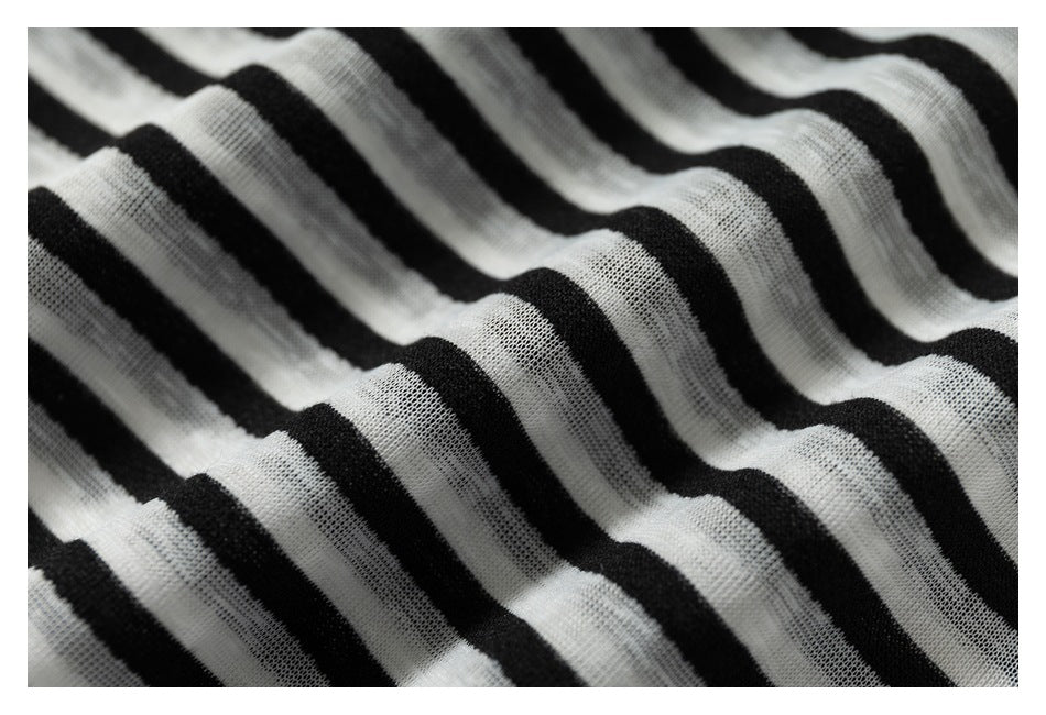 Macro view of the black-and-white striped garment's knit texture and wavy folds.