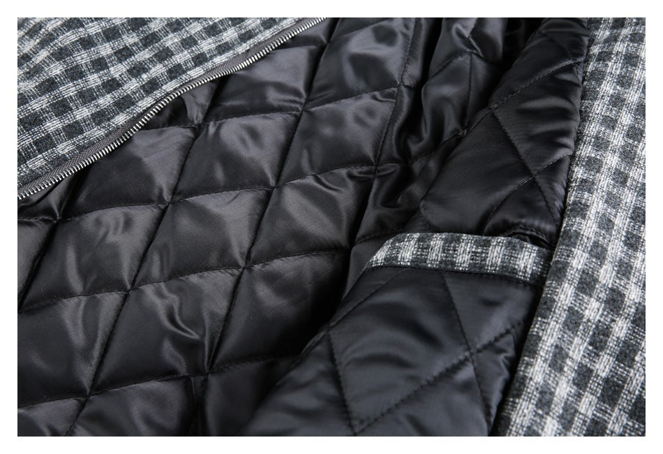 Close-up of a black diamond-quilted jacket lining beside gray plaid fabric and a zipper.