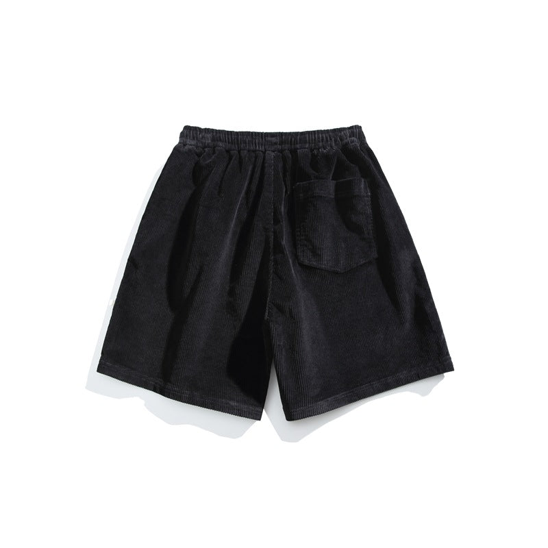 Black corduroy shorts shown from the back, with an elastic waistband and one patch pocket.