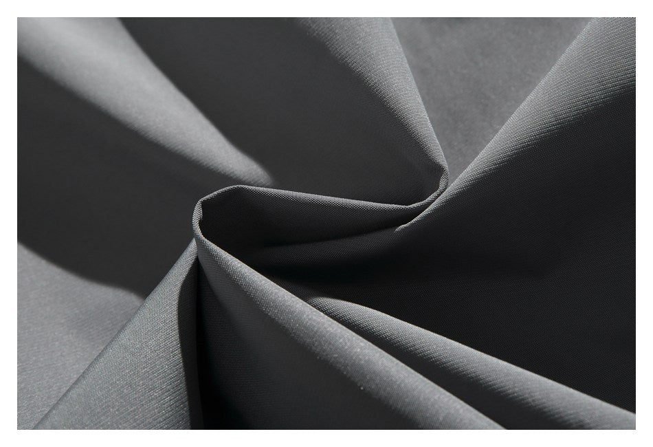 Macro view of smooth charcoal-gray fabric arranged in soft folds.