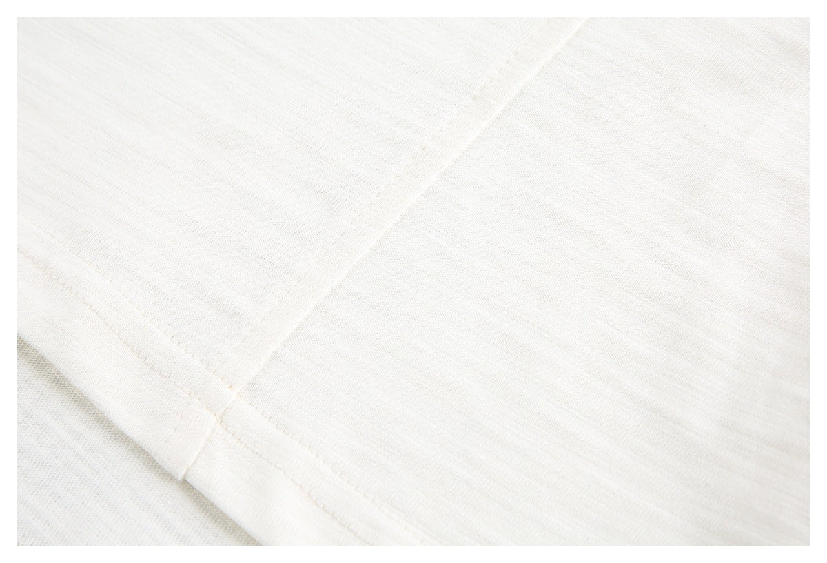 Close-up of off-white knit fabric and intersecting stitched seams.