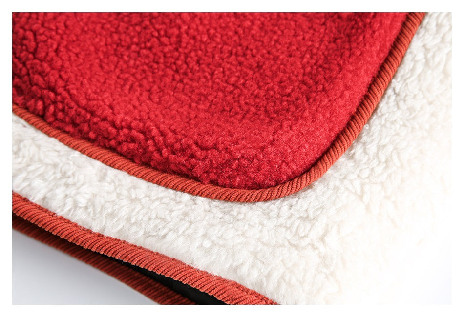 Extreme close-up of a red fleece patch pocket, rust piping, and adjacent white jacket panel.