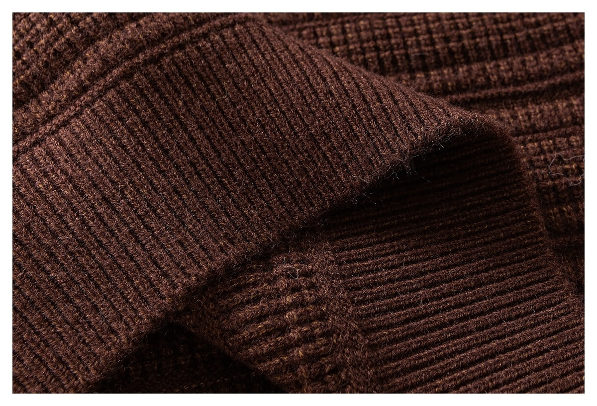 Close-up of a brown knit sleeve cuff and ribbed edge against the sweater body.