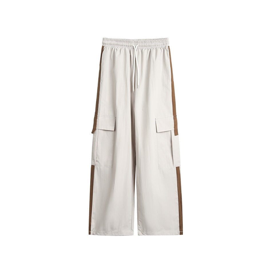 Light khaki wide-leg cargo pants with drawstring waist, flap pockets and brown side stripes, flat front view