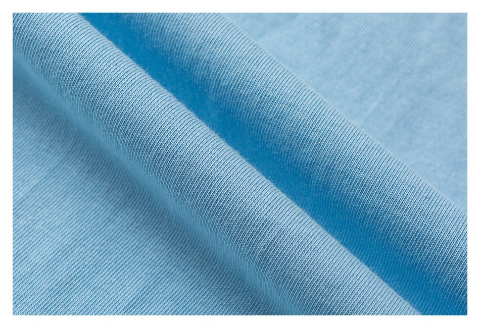Close-up of light blue knit fabric draped in soft folds, showing its fine texture.