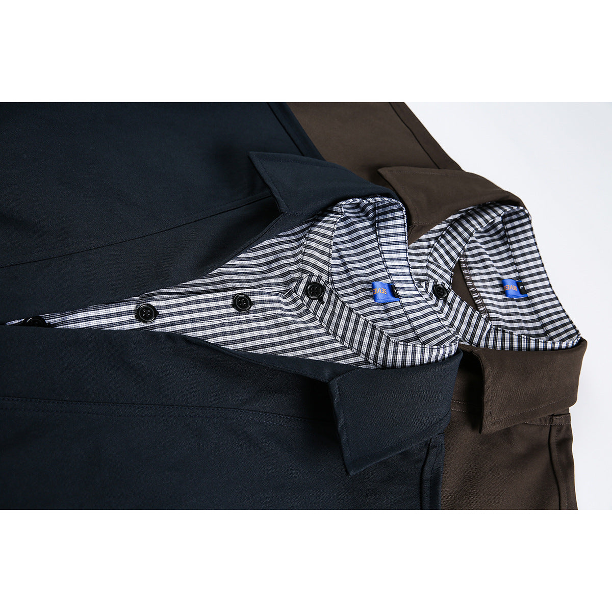 Close-up of the checked inner collars and button plackets on navy and dark brown shirts.