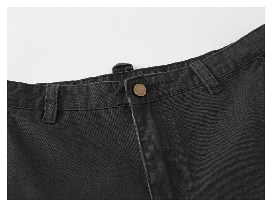 Close-up of the charcoal pants’ front waistband, belt loops, brass-colored button, and fly seam.