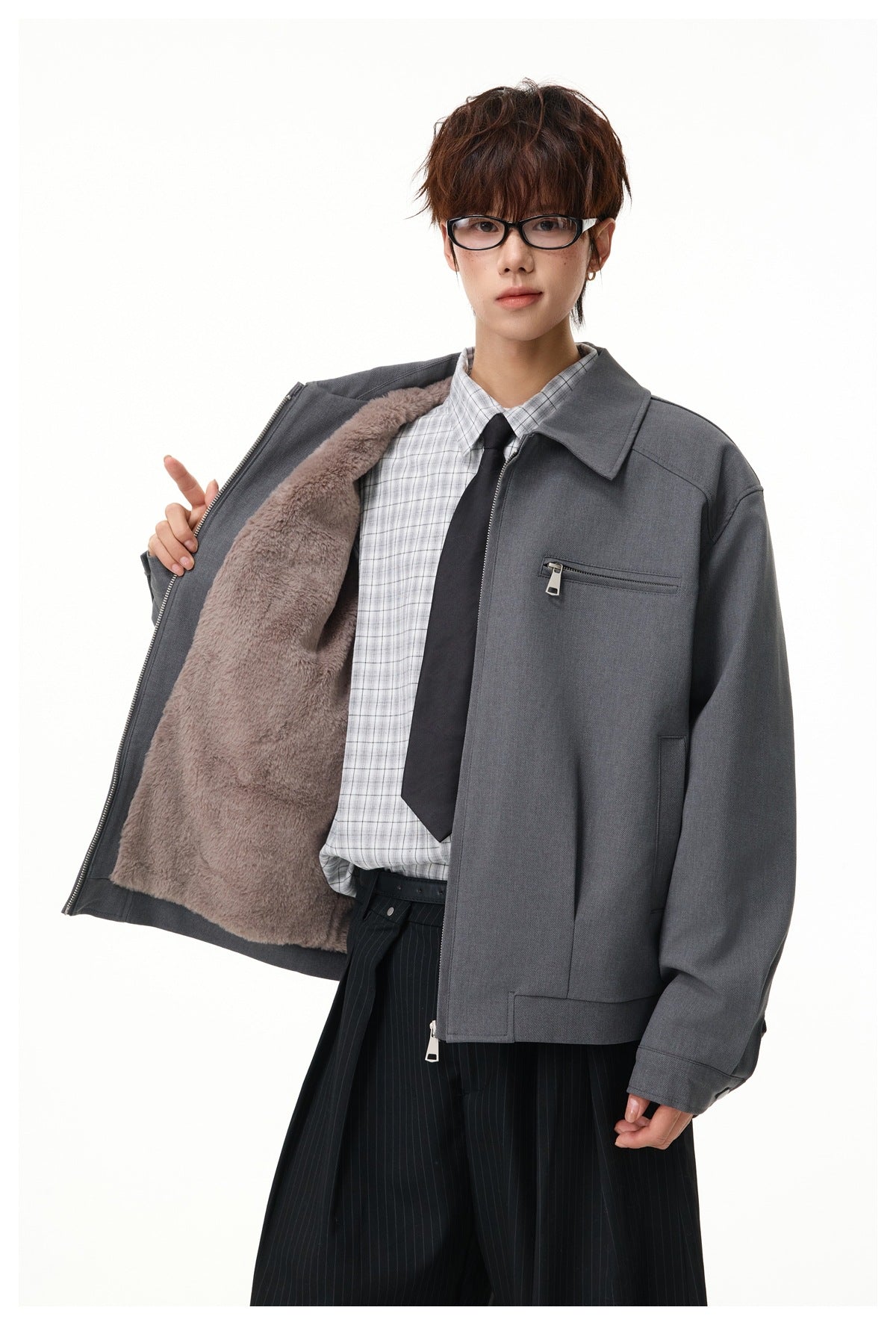Model holds open a charcoal zip jacket to show its plush taupe lining and chest zip pocket.