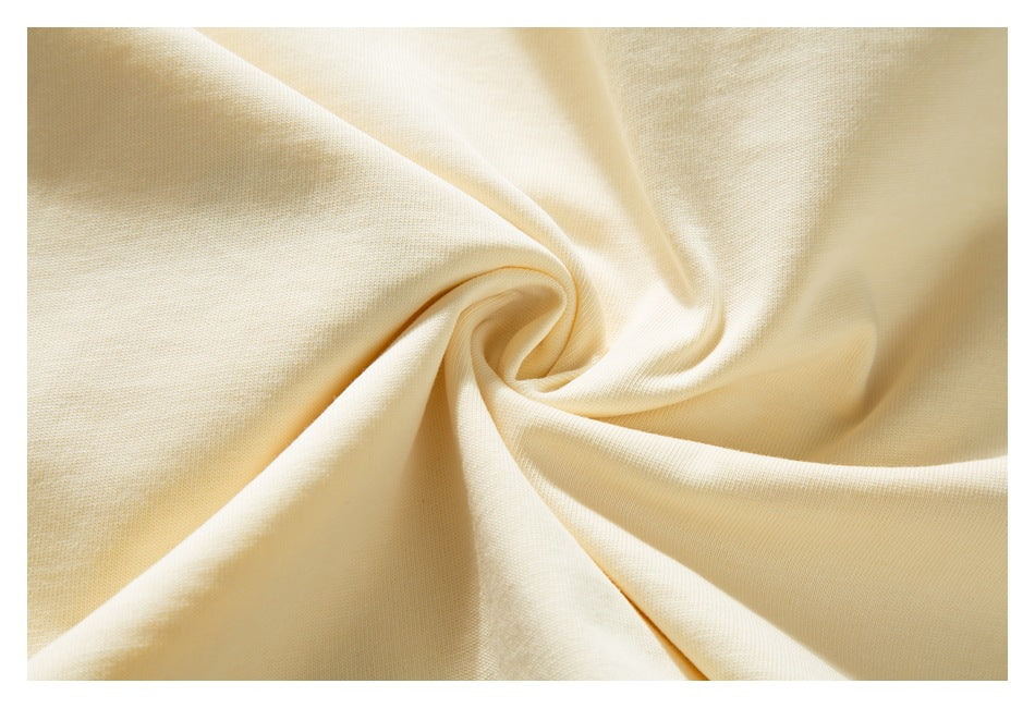 Close-up of softly draped cream fabric gathered into folds.